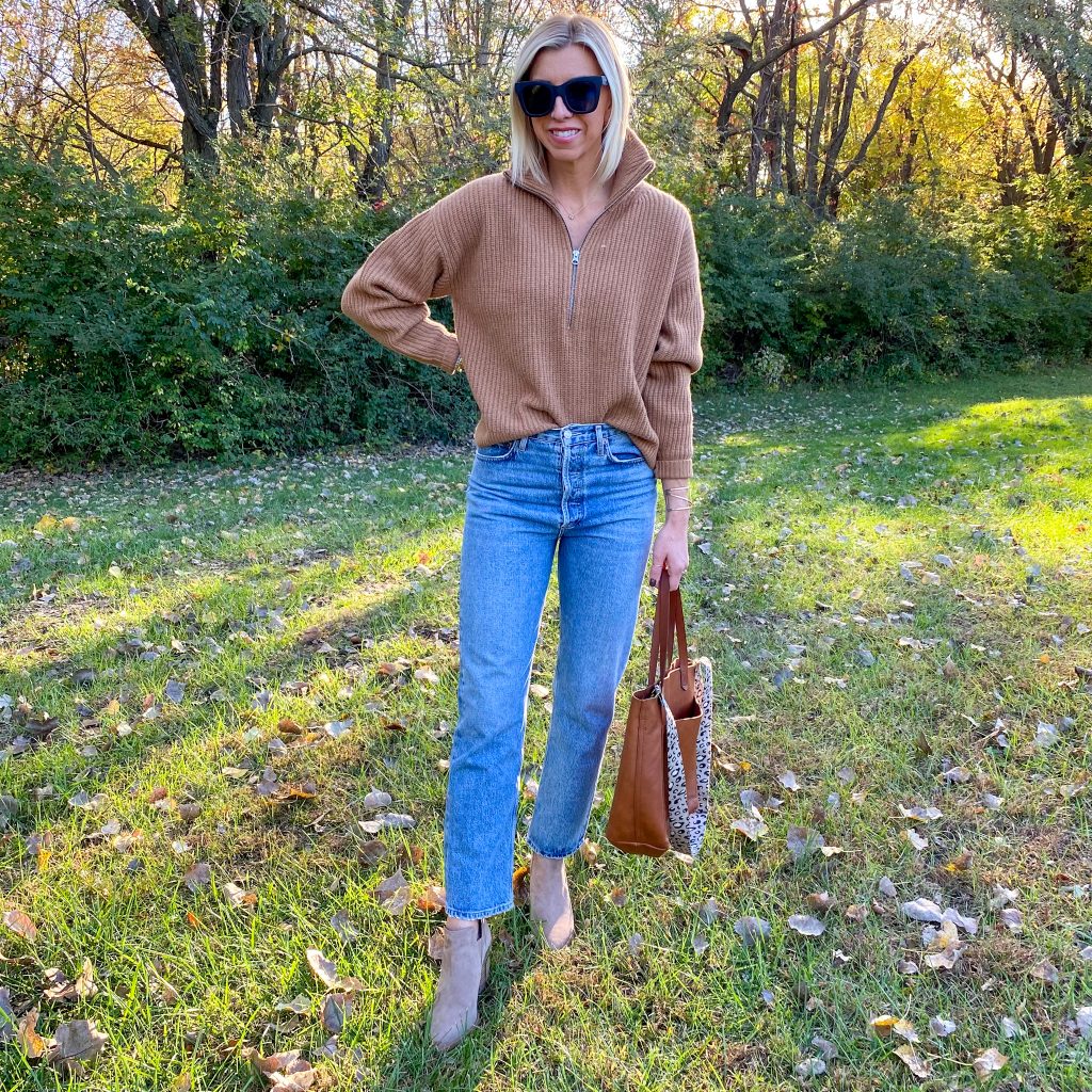 The Haute Homemaker is wear the Everlane Felted Merino wool half-zip sweater, Agolde 90's pinch waist jeans, Vince Camuto boots, Madewell Medium Transport tote bag