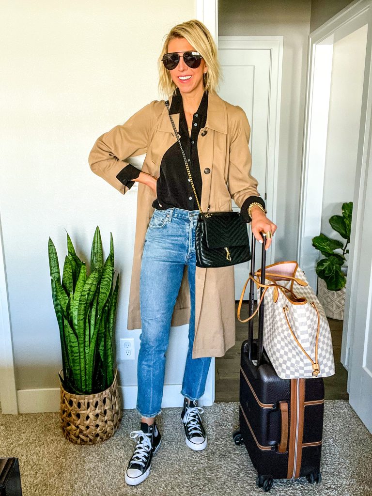 Travel outfit for spring/summer Sarah is wearing straight leg jeans, button up shirt, trench coat, sneakers 