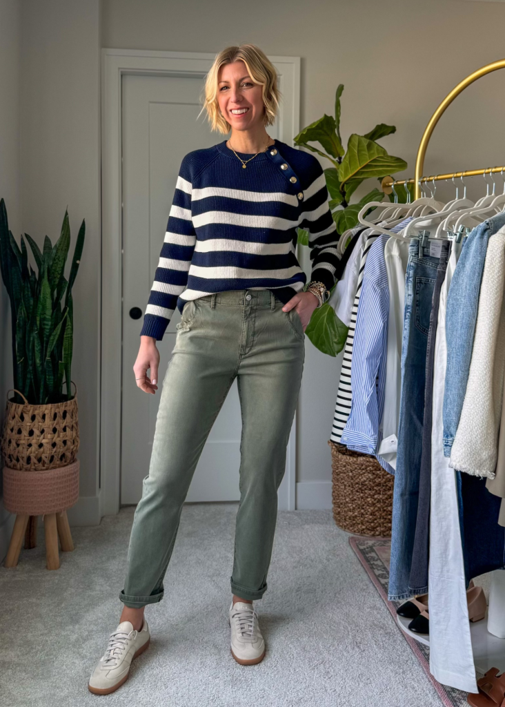 Spring capsule wardrobe outfit with a stripe sweater, green slim fit pants and sneakers
